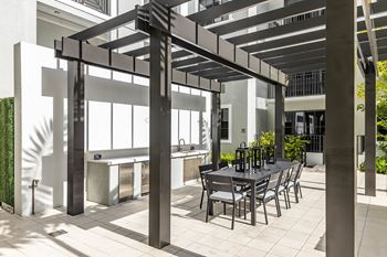 a patio with a table and chairs under a pergola at Leena Plantation, Florida, 33322